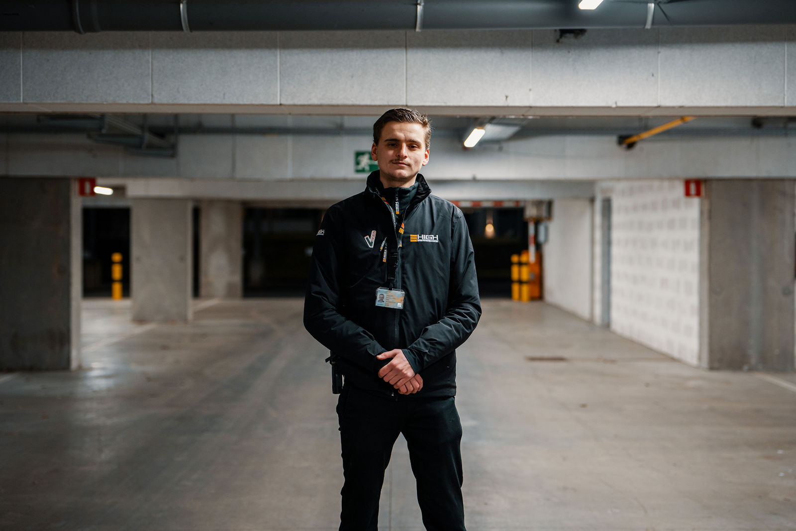 Bewakingsagent van High Security in uniform, staand in een overdekte parkeergarage